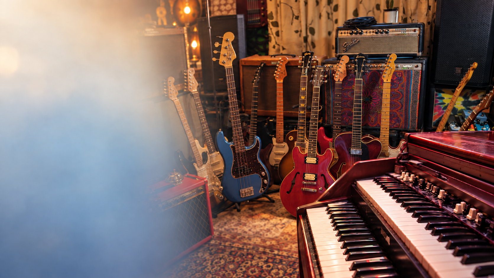 A warmly lit music room with guitars, amplifiers, and keyboards